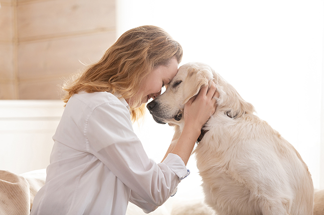 Mujer con perro en sus brazos  Descripción generada automáticamente con confianza media